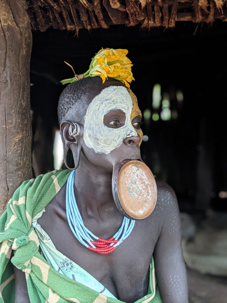 Why do the Mursi or the Suri tribes  adorn themselves with lip plate?